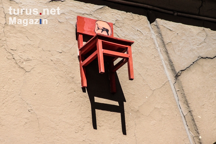 Der rote Stuhl an einer Hauswand