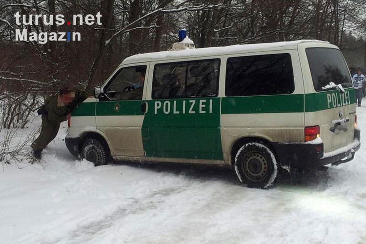 Polizeiauto wird am Olympiastadion aus dem Schnee geschoben