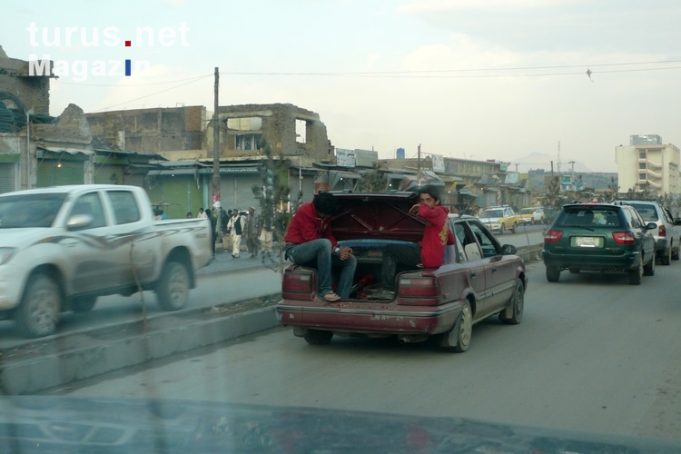 Straßenverkehr in Kabul, Jugendliche sitzen im Kofferraum, Islamische Republik Afghanistan