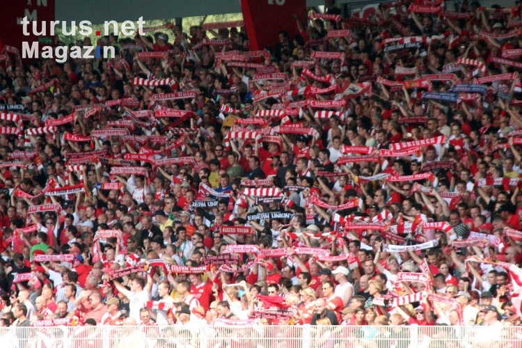 Anhänger des 1. FC Union Berlin halten ihre Schals hoch