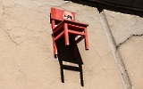 Der rote Stuhl an einer Hauswand