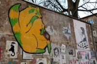 Beklebte und bemalte Werbetafel - Straßenkunst in Berlin Neukölln