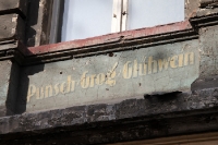 Historische, verwitterte Fassadenwerbung an einer unsanierten Hausfassade in Berlin