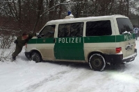 Polizeiauto wird am Olympiastadion aus dem Schnee geschoben