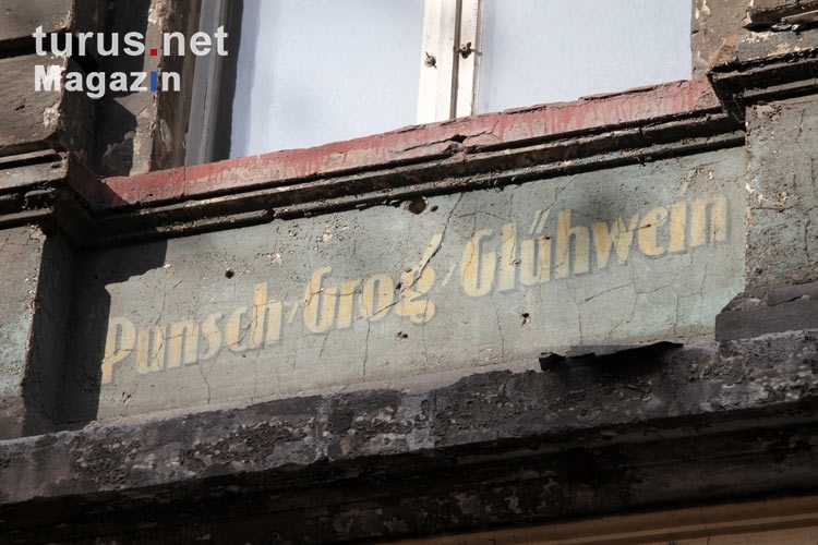 Historische, verwitterte Fassadenwerbung an einer unsanierten Hausfassade in Berlin