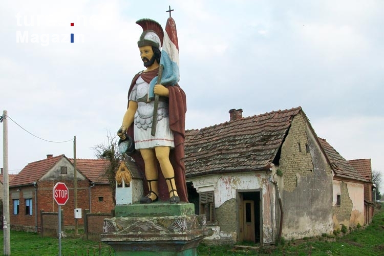 ein kroatischer Nationalheld mit Helm und Flagge in einem Dorf ...