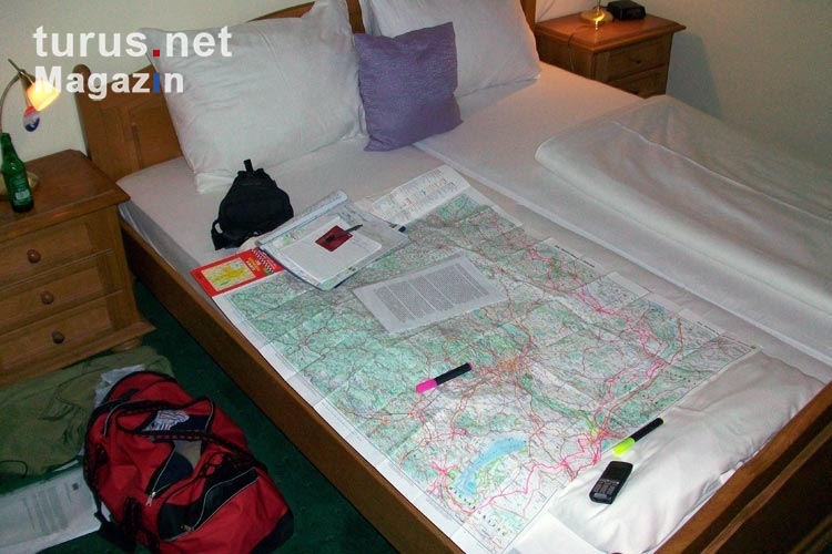 Reiseplanung mit Landkarte auf dem Hotelbett