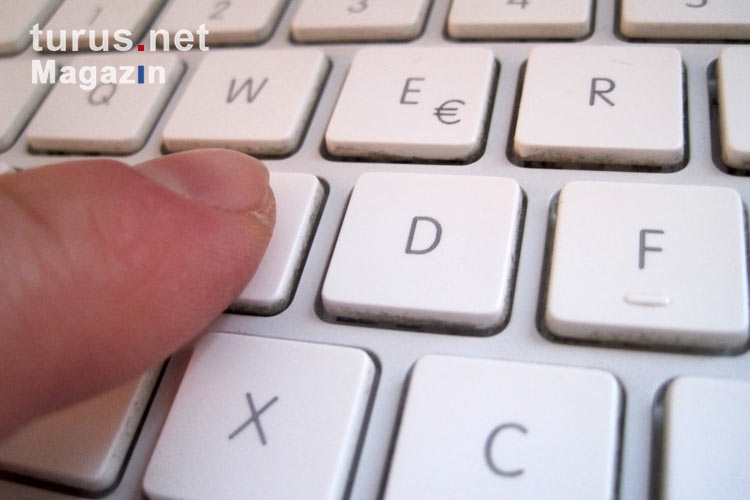 Die Finger auf der Tastatur des Laptops